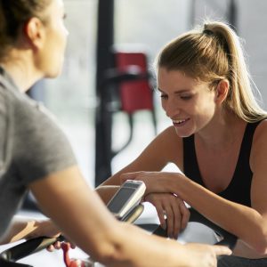 Personal trainer with woman in fitness center
